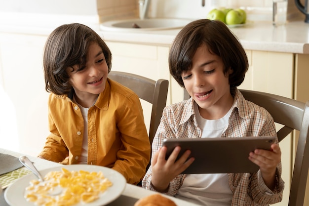 Pequeños gemelos jugando en su tableta