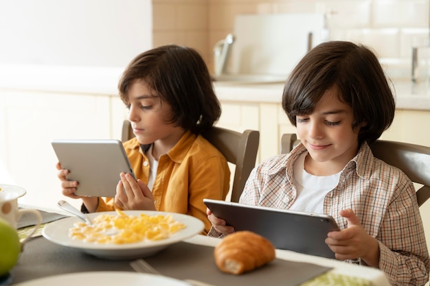 Pequeños gemelos jugando en su tableta