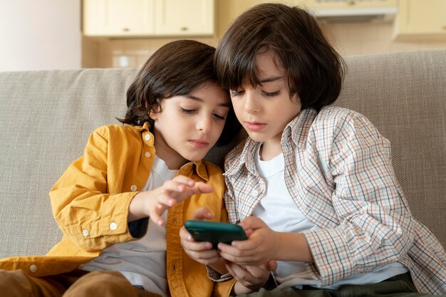 Pequeños gemelos jugando en un teléfono inteligente