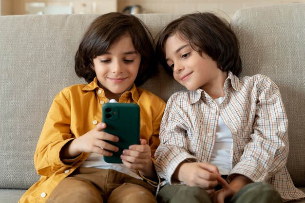 Pequeños gemelos jugando en un teléfono inteligente