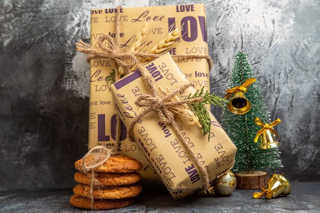 Pequeños y grandes regalos llenos de pie en la pared y galletas