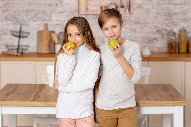 Pequeños hermanos sosteniendo una manzana