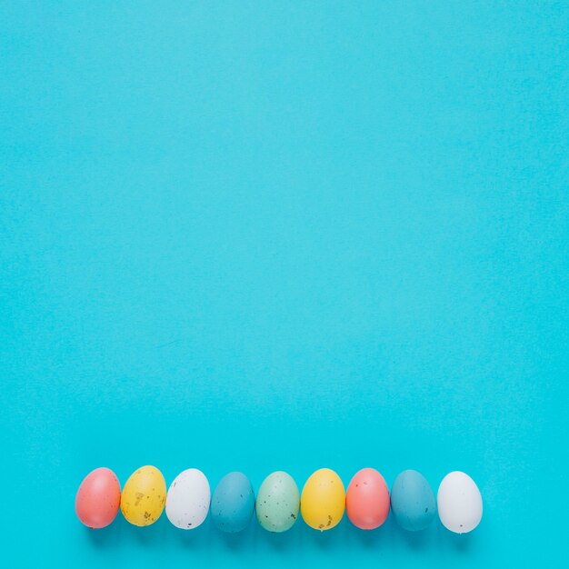 Pequeños huevos de colores en azul en fila