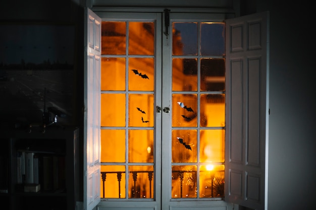 Foto gratuita pequeños murciélagos de papel de halloween en la ventana de la habitación