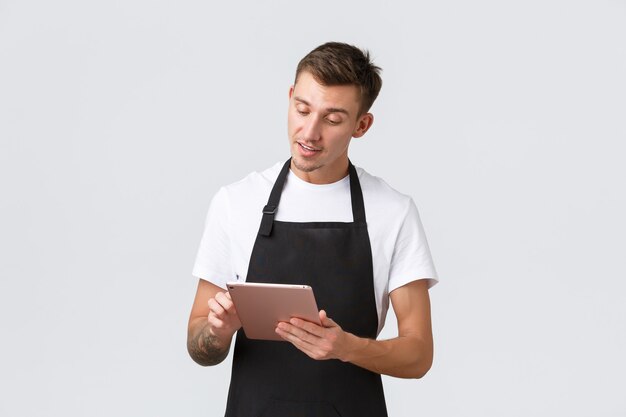 Pequeños negocios cafetería y cafetería empleados concepto guapo joven chico barista camarero tomando orden ...