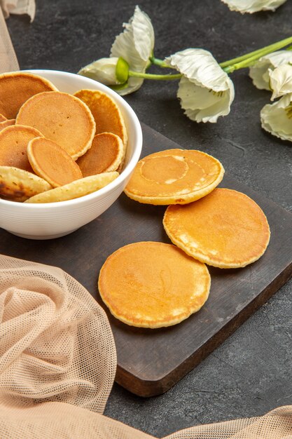 pequeños panqueques con flores blancas sobre gris