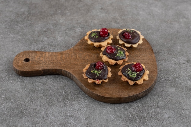 Pequeños pasteles caseros frescos sobre tabla de madera