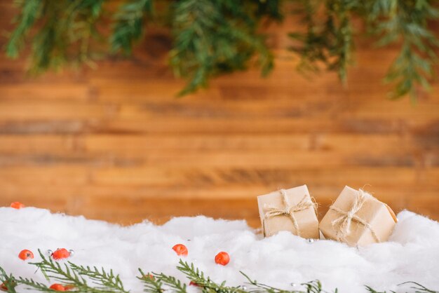 Pequeños regalos en la nieve con ramas de coníferas.