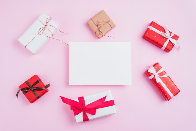 Pequeños regalos de San Valentín alrededor de papel.