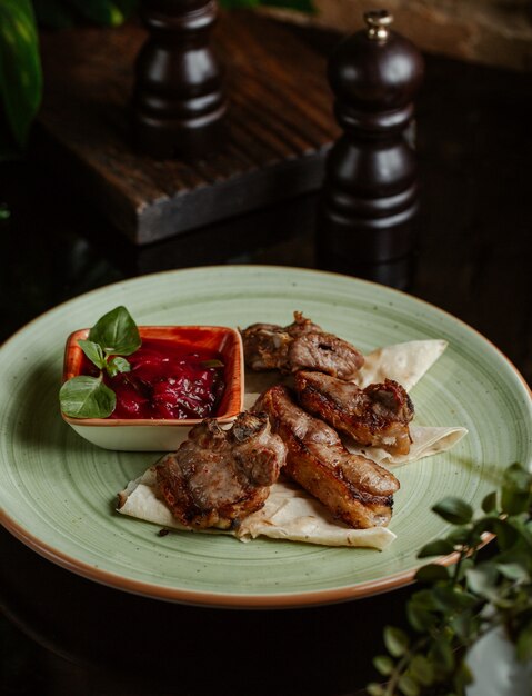 Pequeños trozos de pollo a la parrilla y servidos con salsa de tomate y menta