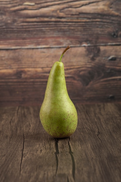 Pera fresca sabrosa única colocada sobre la superficie de madera