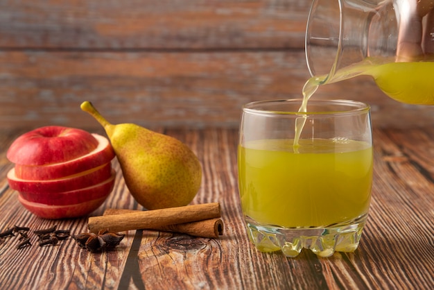Pera verde y manzana roja con un vaso de jugo