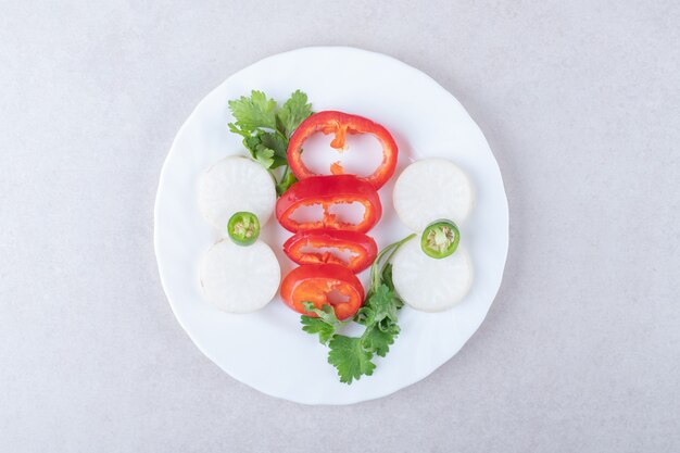 Perejil picado y pimienta en un plato, sobre el mármol.