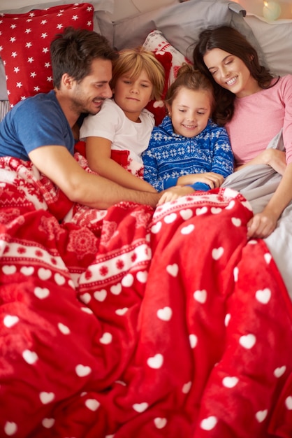 Pereza navideña de la familia en la cama