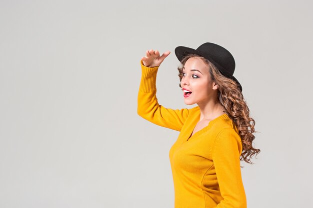 El perfil de la chica emocional con sombrero en gris.