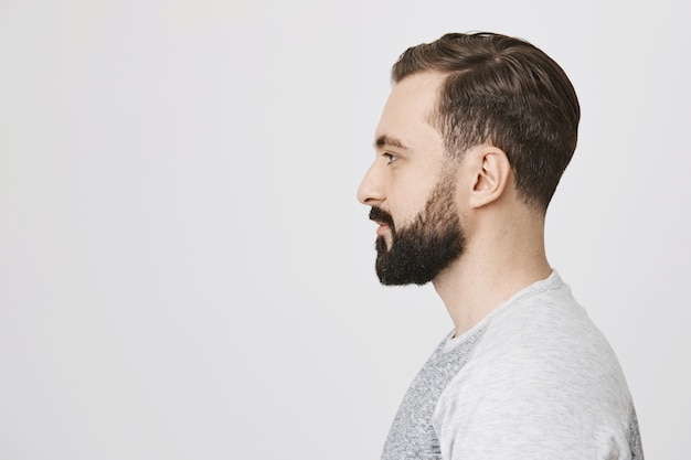 Foto gratuita perfil de hombre barbudo con estilo hizo nuevo peinado en peluquería