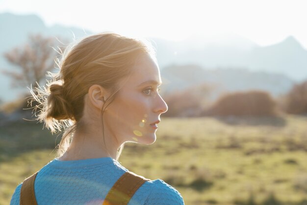 Perfil lateral mujer joven en la luz del sol