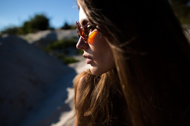 Perfil de mujer bonita en gafas de sol rojas