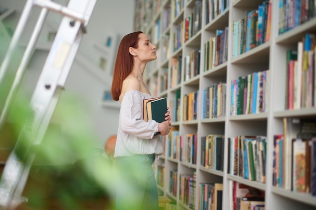 perfil, de, mujer, con, libros, cerca, estantes