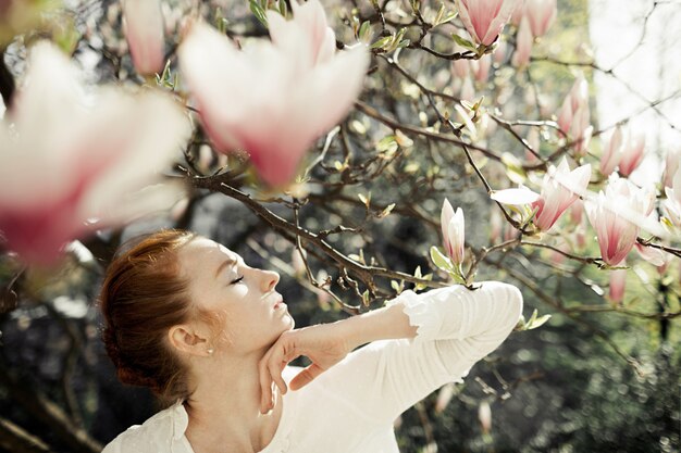 Perfil de niña bonita con flores de magnolia