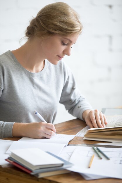 Perfil portait de la muchacha que realiza una tarea escrita en copybook