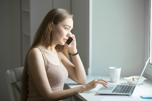 Perfil retrato de una mujer joven, hablando por teléfono