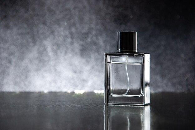 Perfume caro de vista frontal como regalo en la mesa oscura