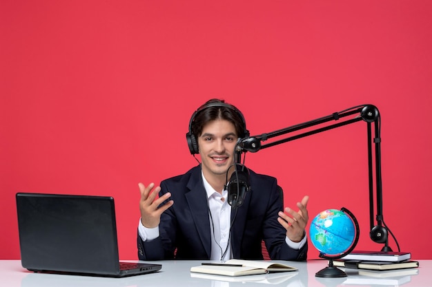 Periodista blogger hablando en video en la computadora un chico lindo en traje negro agitando las manos