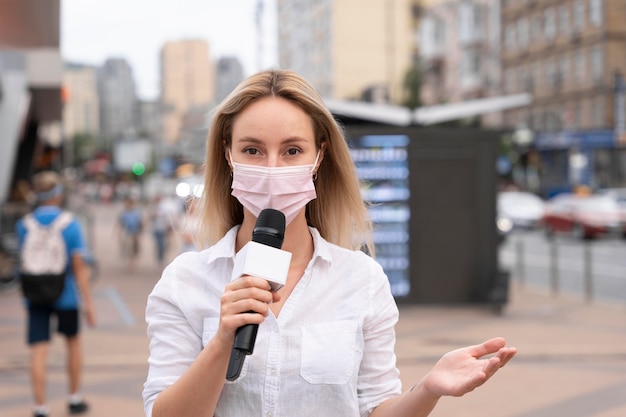 Periodista contando las noticias al aire libre