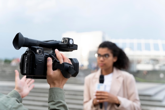 Foto gratuita periodista contando las noticias fuera