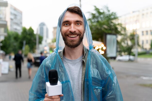 Periodista masculino de vista frontal sosteniendo un micrófono