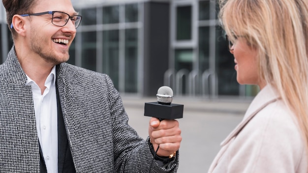 Periodista sonriente haciendo entrevista