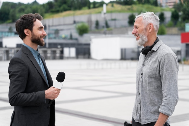 Periodista tomando una entrevista de un hombre