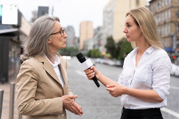 Periodista tomando una entrevista a una mujer