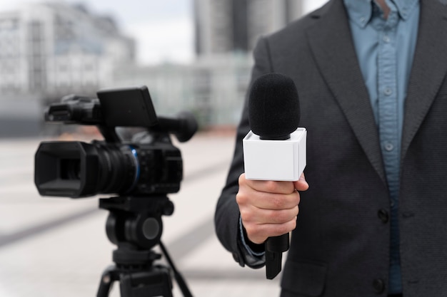 Periodista de vista frontal sosteniendo un micrófono