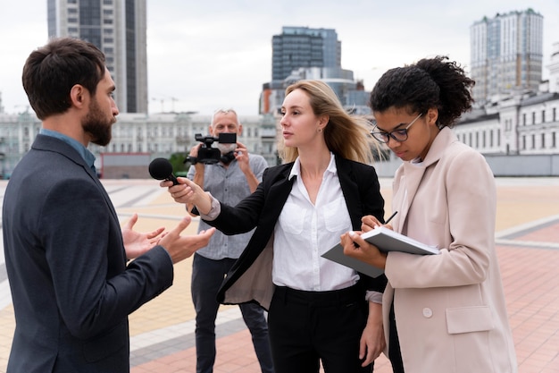 Periodistas que toman una entrevista al aire libre