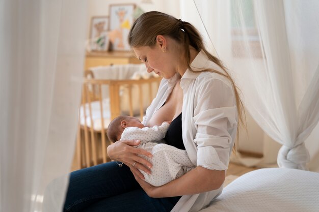 Período postnatal con madre amamantando al niño.