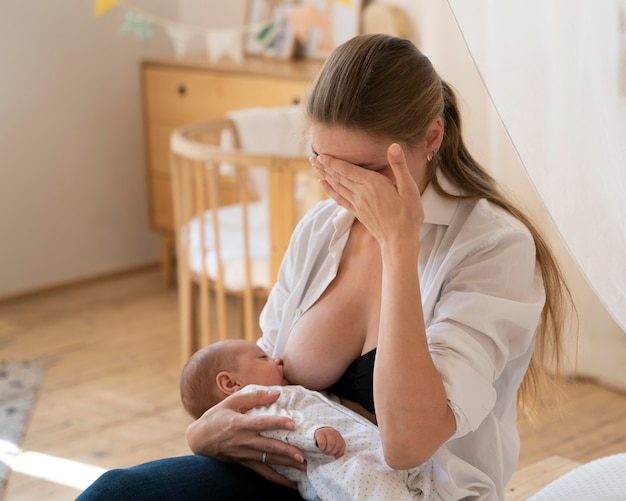 Período postnatal con madre amamantando al niño.