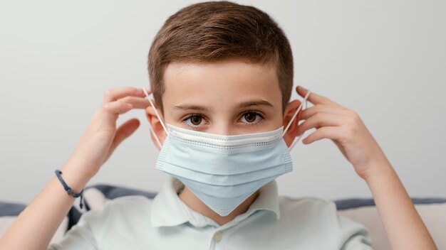 Permanecer en el interior niño con máscara médica