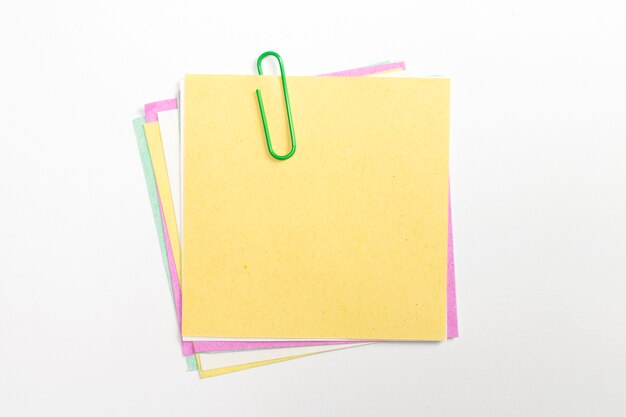 Perno de papel de nota colorido con clips de papel y aislado en blanco.