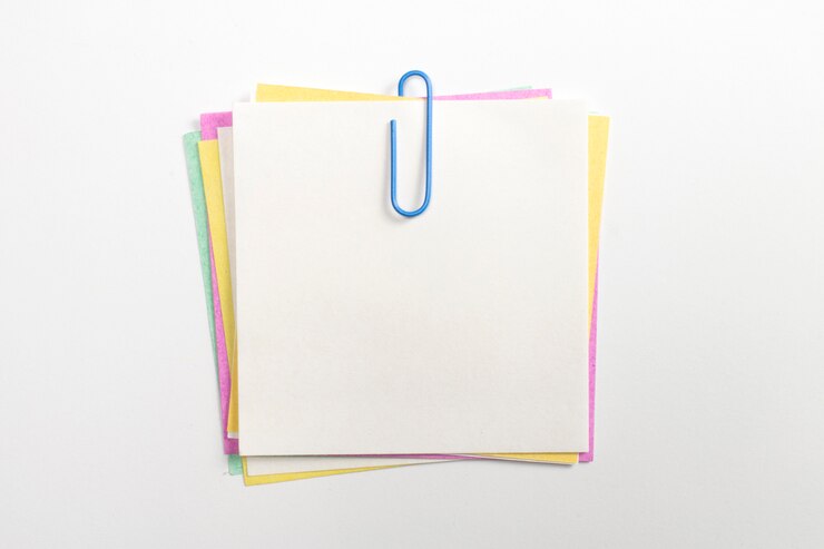 Foto gratuito perno de papel de nota colorido con clips de papel azul y aislado en blanco.