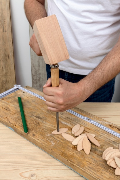 Perón usando un martillo de madera y un destornillador