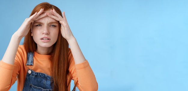 Foto gratuita perpleja insegura linda divertida mujer europea pelirroja buscando a alguien entrecejando los ojos no puede ver sin