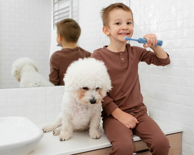 Perrito sentado junto a su pequeño dueño