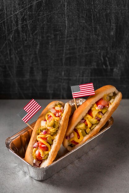 Perritos calientes de ángulo alto con bandera americana en bandeja para hornear