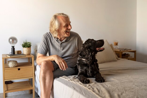 Perro de caricias de hombre sonriente de tiro completo