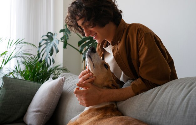 Perro galgo con dueño masculino en casa en el sofá