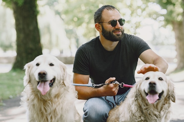 Perro guía ayudando a ciego en la ciudad. Chico ciego guapo tiene descanso con golden retriever en la ciudad.