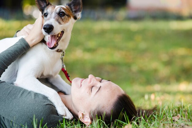 Perro jugando con mujer en pasto