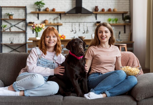 Perro y mujeres sonrientes de tiro completo